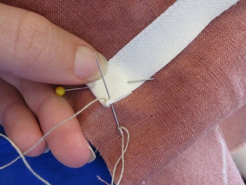 Hand sewing on the hoop channels on my paniers