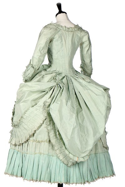 Robe, French, circa 1780, fastening with hooks and eyes, with with box pleated and fly-braid edged robings, fitted back skirts with fixed green silk cords, sold by Kerry Taylor Auctions