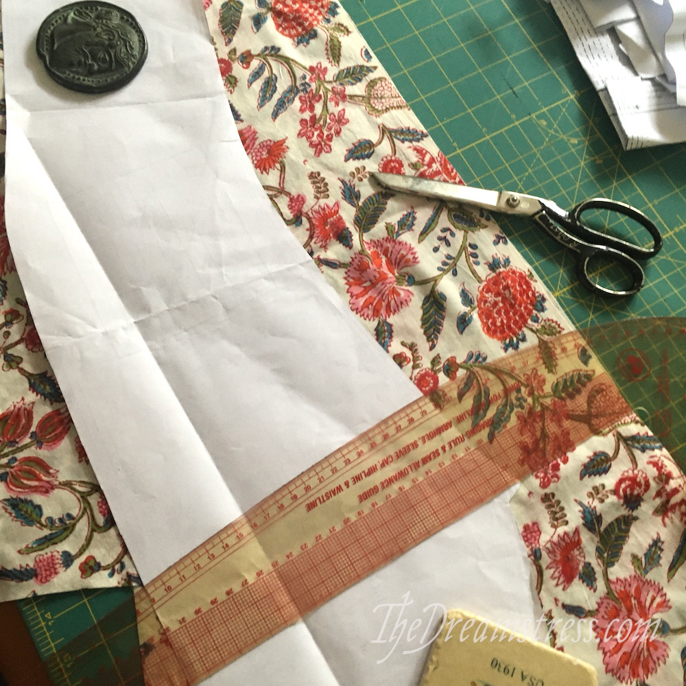 A sleeve pattern piece positioned on floral fabric