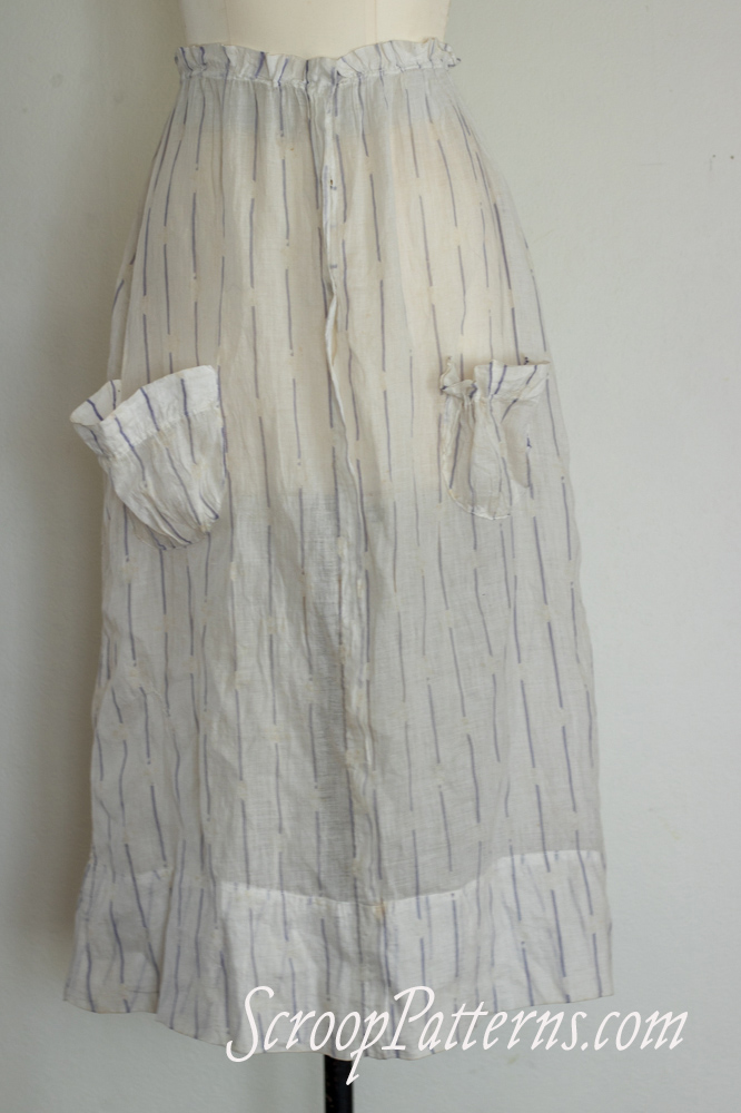 Image shows an antique skirt made of very lightweight white cotton with purple stripes. 