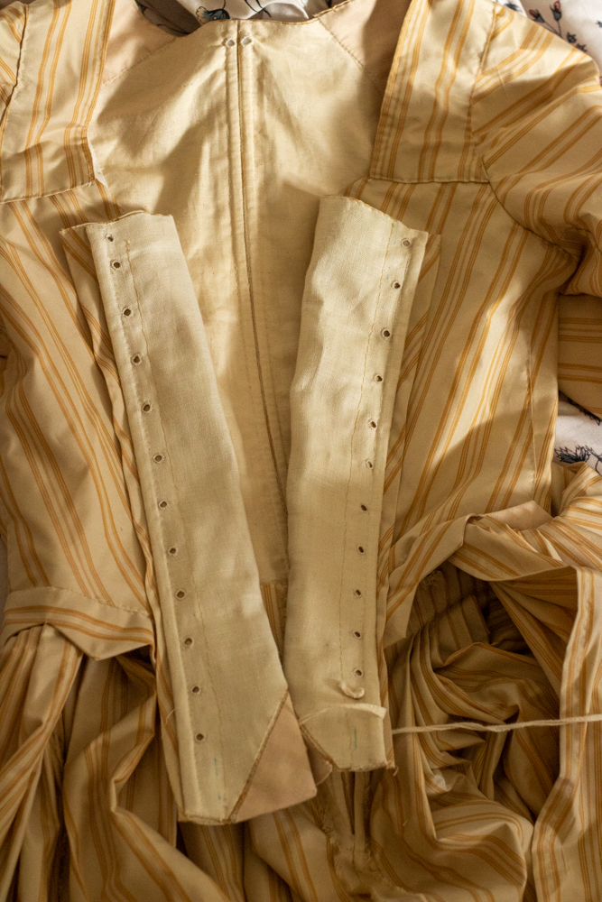 Image shows the interior of an 18th century gown in gold striped silk
