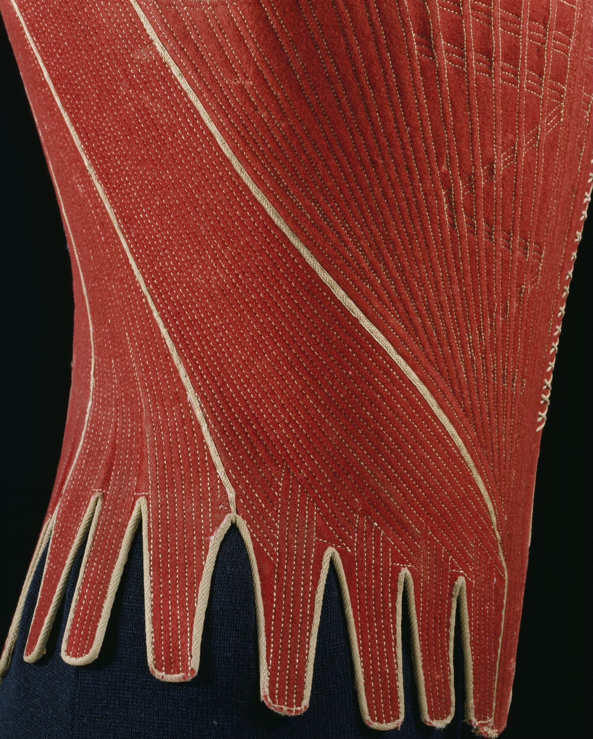 Woman's stays, 1780s, British; Red wool trimmed with cream silk, boned, back lacing, laced shoulder straps T192.1929